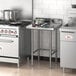 A Regency stainless steel open base work table in a professional kitchen.