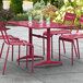 A red Lancaster Table & Seating outdoor table with chairs on a patio.