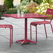 A red Lancaster Table & Seating dining table with chairs on a patio.