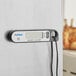 A black AvaTemp digital thermometer with a white screen and a magnet on the back.