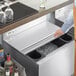 A Regency stainless steel sliding lid on a counter over a bar ice bin.