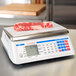 A Cardinal Detecto digital counting scale on a counter with a piece of raw meat.