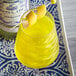 A glass of yellow liquid with a Spirdust yellow lemon wedge on a toothpick.