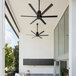 A Big Ass Fans black aluminum i6 outdoor ceiling fan in a room on an outdoor patio.
