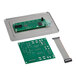A green circuit board with a small computer chip and silver screws.