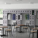 A room with tables and chairs and Regency lockers.