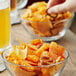 A bowl of pretzels and chips on a table in a stadium concession stand.