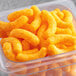 A plastic container of Good's Cheese Curls on a table.