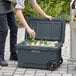 A man putting bottles into a CaterGator outdoor cooler.