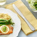 A plate of salmon, asparagus, and rice with an Acopa Vittoria stainless steel table knife.