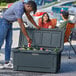 A man wearing a hat putting a can in a CaterGator outdoor cooler.