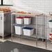 A Regency chrome metal shelving unit with a wood top.