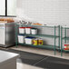 A kitchen with a green metal Regency shelf on a white counter.