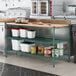 A kitchen with a wooden cutting board shelf insert on green Regency shelves.