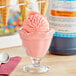 A glass cup of pink ice cream with LorAnn Watermelon Cooler syrup on top.