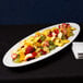 An American Metalcraft oval melamine boat platter with fruit on a table.