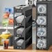 A black ServSense countertop organizer with sections for lids and straws.