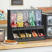 A ServSense black countertop condiment organizer with 10 sections.