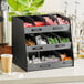 A black ServSense countertop condiment organizer with 11 sections.