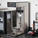 A Bunn iced tea brewer on a counter with a tea dispenser.