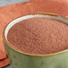 A bowl of chocolate popcorn glaze powder on a table.