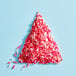 A pile of Adourne Valentine's Day sprinkle mix on a blue surface.