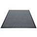 A grey Berber carpet with black rubber border.