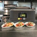 Three plates of food vacuum packaged with an ARY VacMaster VP330 on a table.