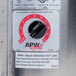 An APW Wyott stainless steel round countertop cooker/warmer with a black knob and white text.