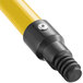 A close up of a yellow Lavex metal broom handle.