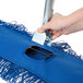 A hand using a Lavex swivel snap wire mop frame to clean a floor.