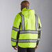 A man wearing a Cordova Hi-Vis lime green quilted parka with reflective striping over a yellow vest.