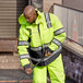 A man wearing a Cordova Hi-Vis Lime yellow jacket holding a black pole.