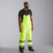 A man wearing Cordova Hi-Vis lime yellow quilted bib pants.