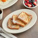 An Acopa ivory stoneware platter with french toast, berries, and coffee on it.