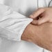 A person's hands holding a white Malt Impact ProMax disposable lab coat.