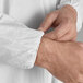 A person wearing a white Malt Impact ProMax coverall with elastic wrists and ankles.