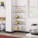 A metal Regency triangle wire shelf kit in a kitchen with cans on it.