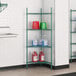 A green metal Regency wire shelving unit with containers of liquids.