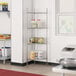 A school kitchen with a Regency chrome wire shelf kit holding cans of food.