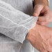 A person wearing a Malt Impact white polypropylene lab coat with open wrists.