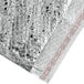 A silver foil bubble wrap bag with red and white writing containing a Lavex Lite insulated box liner.