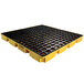 A yellow pallet with black grates for 4 drums.