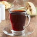 A glass cup of Ellis Mezzaroma medium roast coffee on a saucer.