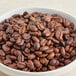 A bowl of Ellis Mezzaroma Royal Sumatra whole bean coffee on a table.