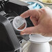A person using Ellis 100% Colombian Coffee Single Serve Cups to make coffee.