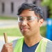A man wearing Honeywell Uvex safety glasses and a reflective vest while holding a pipe.