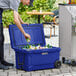 A man putting a can of beer into a navy CaterGator outdoor cooler filled with bottles.