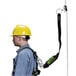 A man wearing a hard hat and safety harness using a Honeywell Miller rope grab.