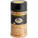 A jar of 24K edible gold crumbs on a counter.